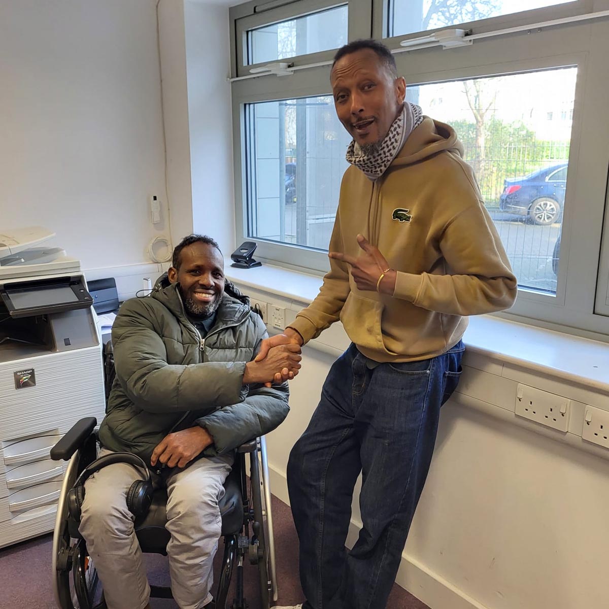 Community support worker and wheelchair user smiling together